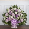 Standing floral spray with pink, white, and purple flowers on a white easel