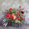 Bright mixed flower arrangement in a square textured vase