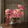 Pink and peach roses arranged in a silver vase