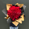 Large bouquet of red roses wrapped in black and gold paper