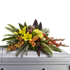 Bright mixed floral spray on a white casket