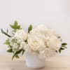 White roses and hydrangeas arranged in a white vase