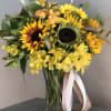 Yellow sunflower bouquet in a glass vase with ribbon