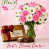 Pink and white flower bouquet in a glass vase with a box of chocolates