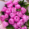 Bouquet of bright pink peonies with dark green leaves