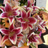 Bouquet of pink stargazer lilies, roses, and gerbera daisies with butterfly picks