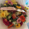 Mixed bouquet with roses, gerbera daisies, and yellow tulips, wrapped with a birthday ribbon
