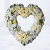 Heart-shaped floral wreath of white and pale yellow roses
