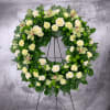 Large floral wreath with white roses, pale orchids, and green pom-pom flowers