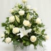 White roses and lilies arranged in a white vase