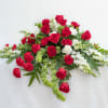 Red roses and white flowers arranged in a low spray