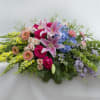Low floral spray with pink lilies, roses, hydrangeas, and yellow blooms