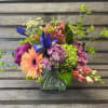 Colorful mixed bouquet in a clear glass vase with gerbera, iris, and hydrangea