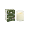 Scented white candle in a clear glass holder beside a green floral-patterned box