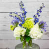 Blue and white flowers arranged in a clear glass vase