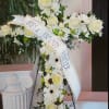 Standing floral cross of white roses and gerbera daisies with a Best Friends Forever ribbon.