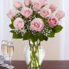 Pink roses arranged in a clear glass vase with baby's breath
