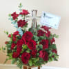 A keepsake crystal cross surrounded by florals in red roses and mini