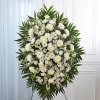 White funeral spray with daisies and roses on a stand