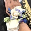 A cool-toned wrist corsage and matching boutonniere set designed for prom, wedding