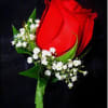A single red rosebud corsage and matching boutonniere crafted for romantic occasions