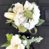 Delicate cream-and-white blooms shaped into a classic white corsage and matching boutonniere