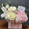 Welcome a sweet baby girl with this beautiful floral purse arrangement featuring