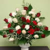 Red and white roses with carnations in a white vase