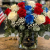 Bouquet of red, white, and blue roses in a glass vase