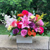 Colorful mixed flower arrangement in a white rectangular box