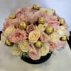 Bouquet of pale pink and cream roses with gold-wrapped chocolates in a black box