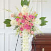 Standing floral spray with pink roses and white chrysanthemums on an easel