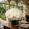White rose and hydrangea arrangement in a dark green vase