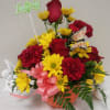 Birthday flower arrangement with red roses and yellow daisies in an orange pot