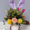 Floral arrangement in a bunny-shaped vase with tulips, roses, and bunny ears