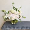 White and blush floral arrangement in a round glass vase