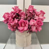 Pink rose arrangement in a round hat box with a tassel tie