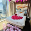 Bedroom decorated with pink heart-shaped petals and balloons
