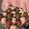 Box of chocolate-covered strawberries with pink and brown coatings