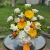 Bouquet of yellow, white, and orange flowers with a ribbon