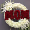 Large floral standing wreath with red and white flowers on an easel