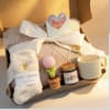Soft pink knit blanket, fuzzy cream socks, and a ribbed white ceramic