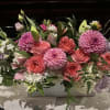 Soft pink roses and large pink dahlias create a lush, romantic centerpiece