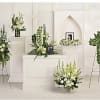 White and green funeral floral arrangements on stands and pedestals