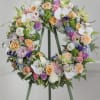 Pastel floral wreath on a stand with roses and white orchids