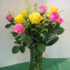 Bouquet of yellow and pink roses in a clear glass vase