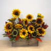 Sunflower arrangement in a wooden box with red berries and autumn leaves