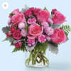 Pink roses and small lavender blooms in a clear glass vase