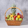 Wicker basket filled with assorted fruit including pineapple, grapes, apples, pears, bananas, and kiwi