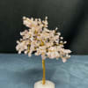 Small crystal tree with pale pink stones on a white base